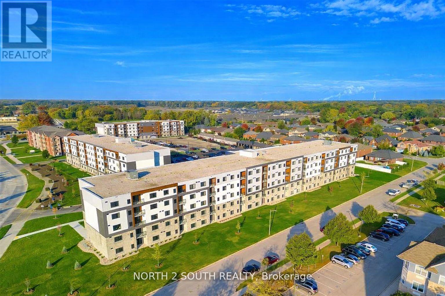 A large apartment complex with a parking lot in front.