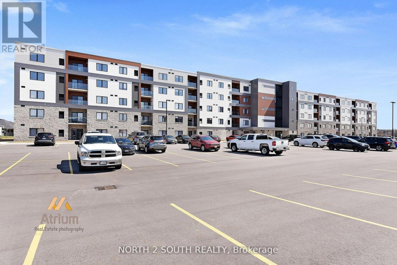 A parking lot with cars and a multi-story apartment building in the background.