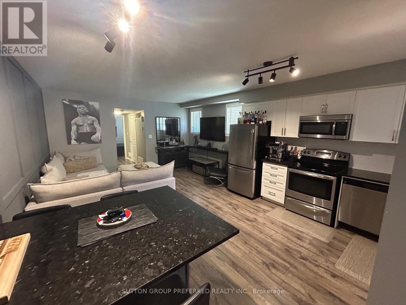 A kitchen with a black granite countertop and stainless steel appliances.
