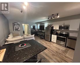 A kitchen with a black granite countertop and stainless steel appliances.