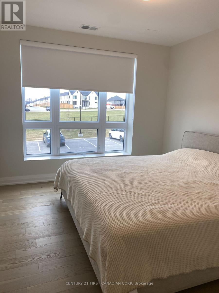 A bedroom with a large bed and a view of a parking lot through the window.