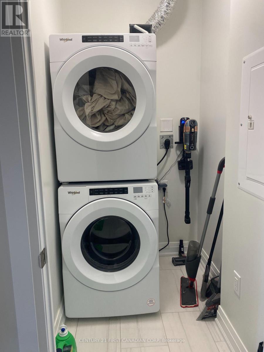 A white Whirlpool washing machine and dryer in a small laundry room.