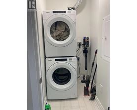 A white Whirlpool washing machine and dryer in a small laundry room.