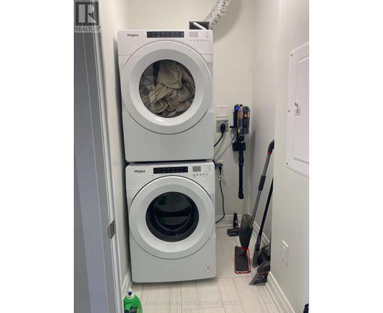 A white Whirlpool washing machine and dryer in a small laundry room.
