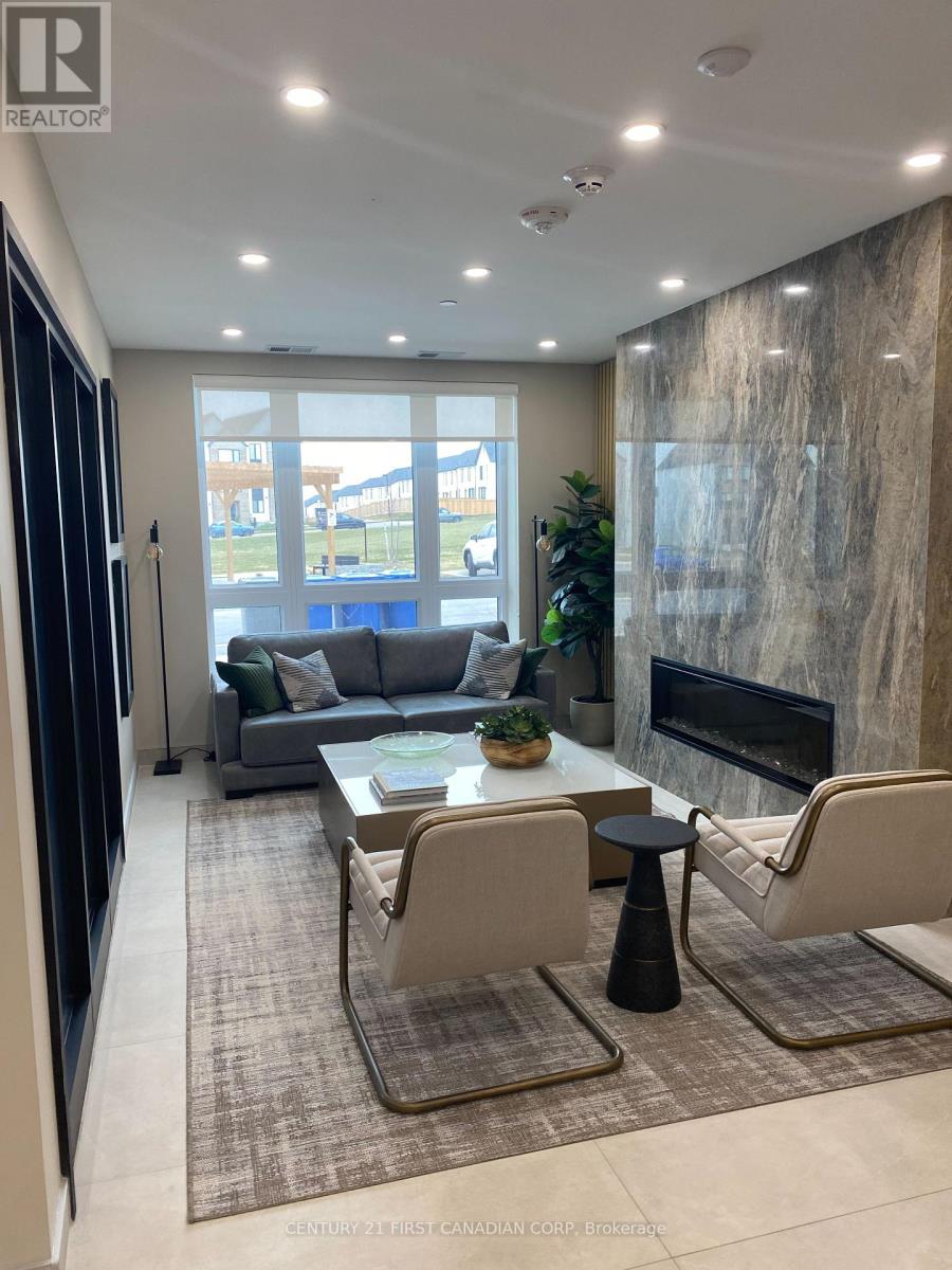 A modern living room with a grey sofa, a black fireplace, and a glass door leading to a balcony.