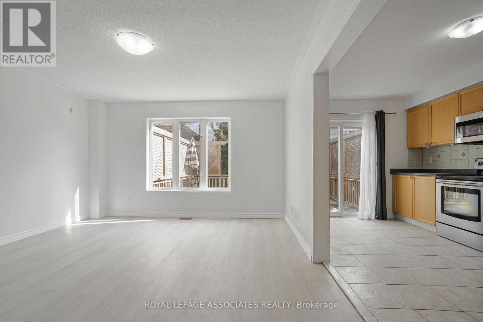 A spacious, empty room with a view of a building outside the window.