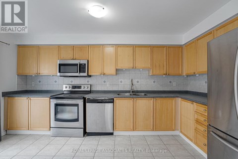 A kitchen with wooden cabinets and stainless steel appliances.