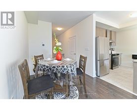 A dining room with a table set for two and a refrigerator in the background.
