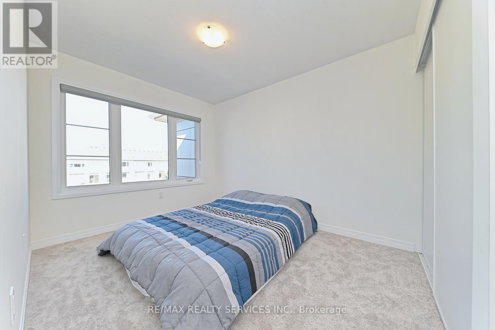A bedroom with a bed and a window.
