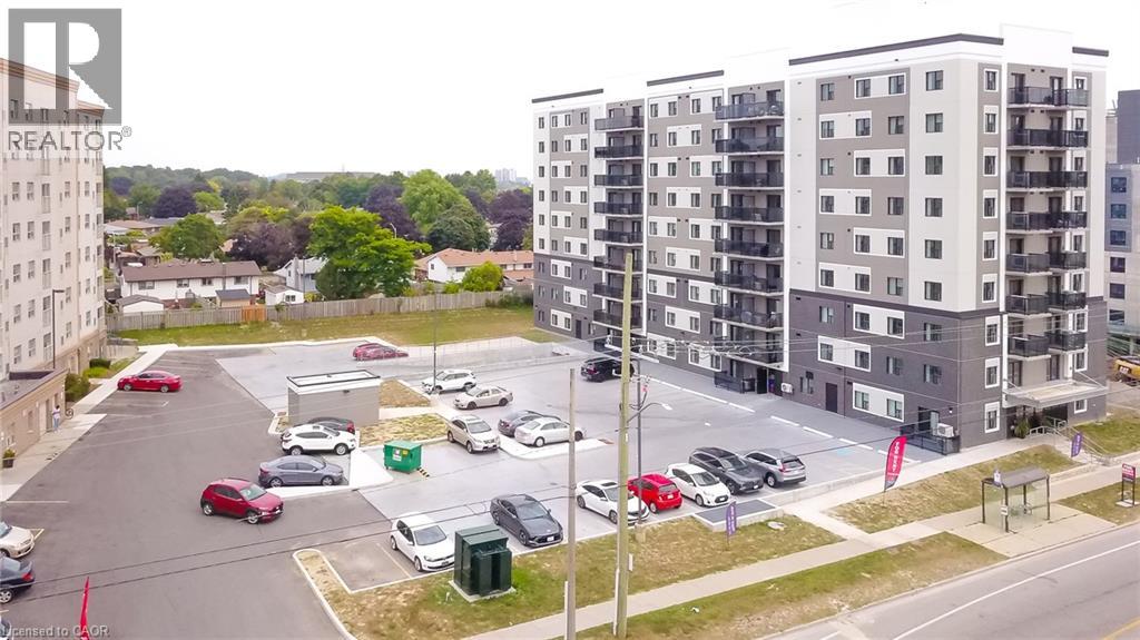 A parking lot with cars and apartment buildings in the background.