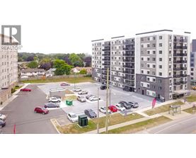 A parking lot with cars and apartment buildings in the background.