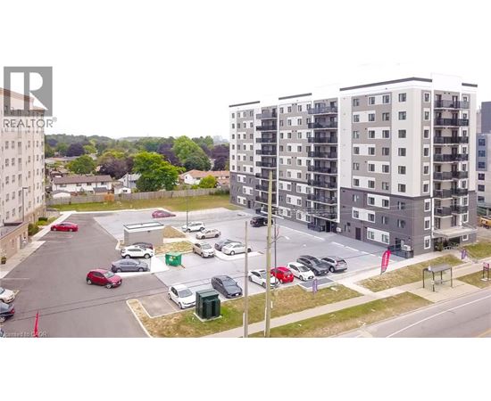 A parking lot with cars and apartment buildings in the background.
