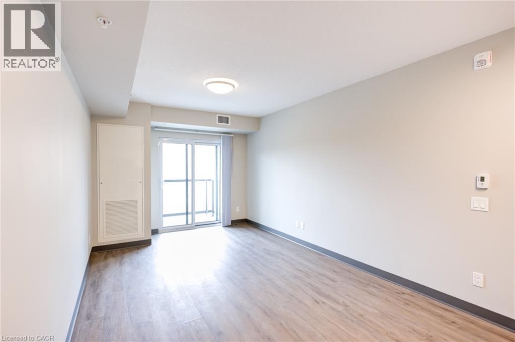 A spacious room with a sliding glass door leading to a balcony.