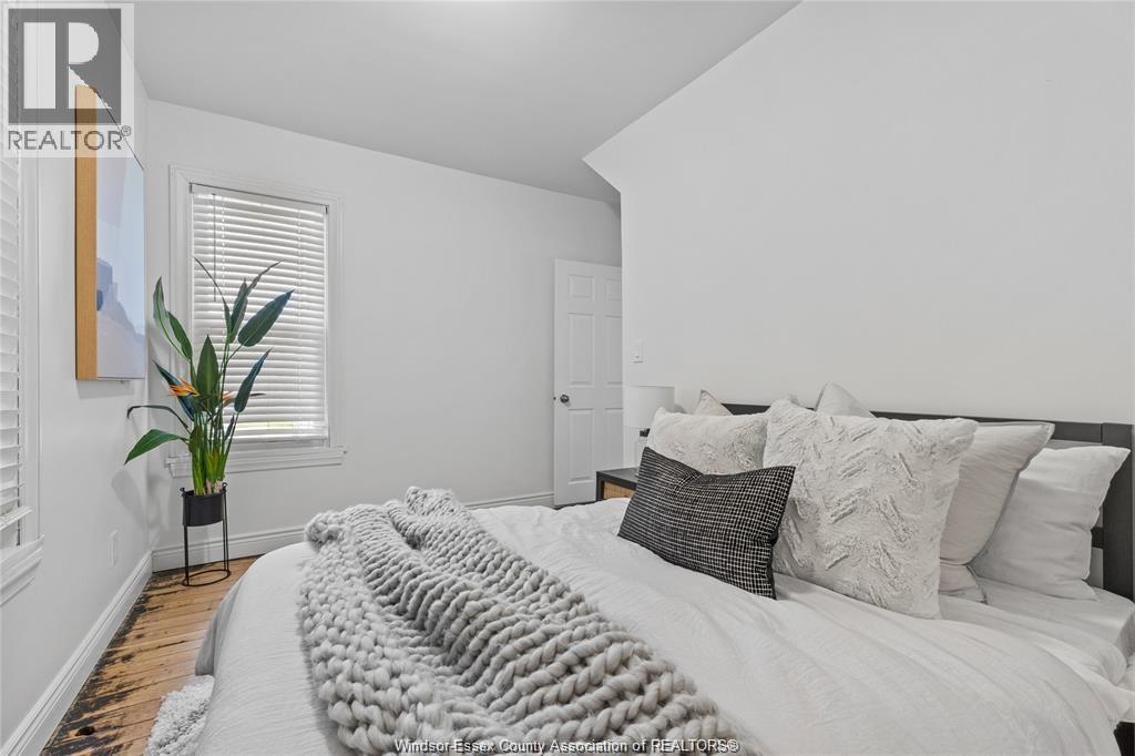 A bedroom with a large bed and a potted plant.
