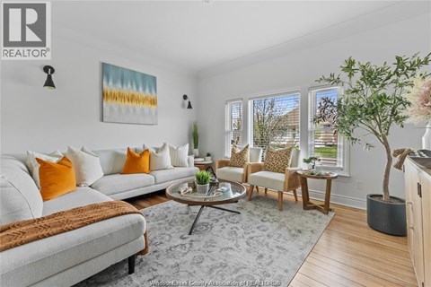 A living room with a white couch, a coffee table, and a painting on the wall.