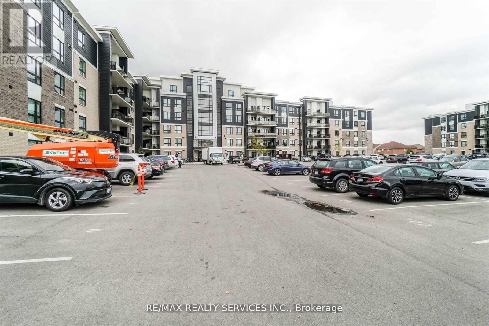 A parking lot with cars and apartment buildings in the background.