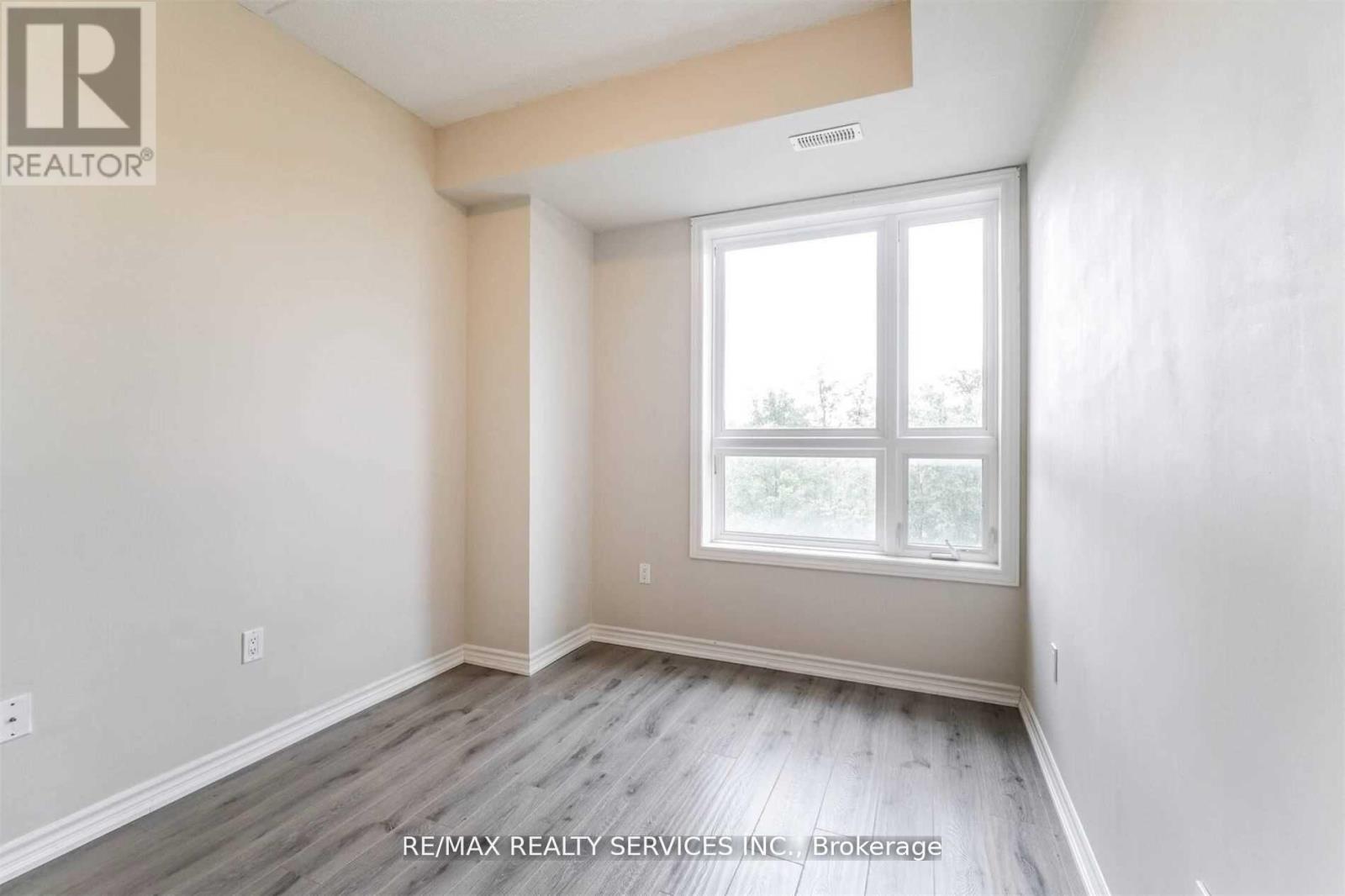 A room with a window and wooden flooring.