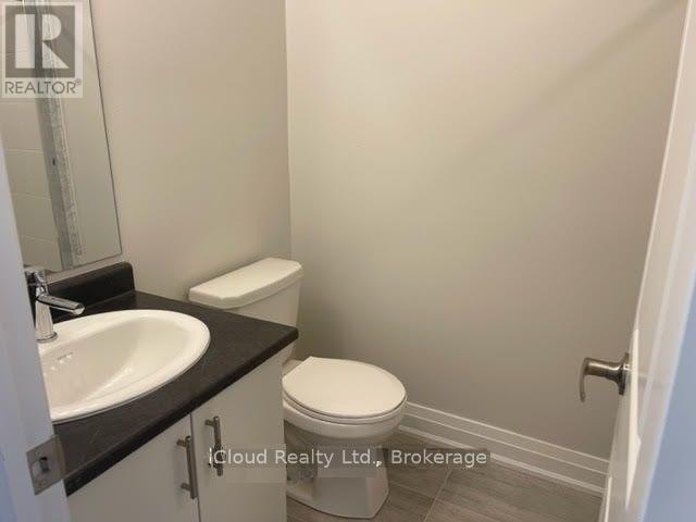 A small bathroom with a toilet, sink, and cabinet.