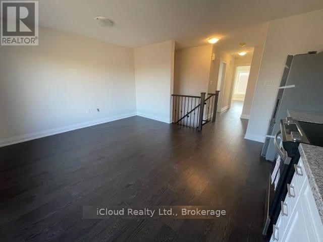A spacious living room with wooden floors and white walls.