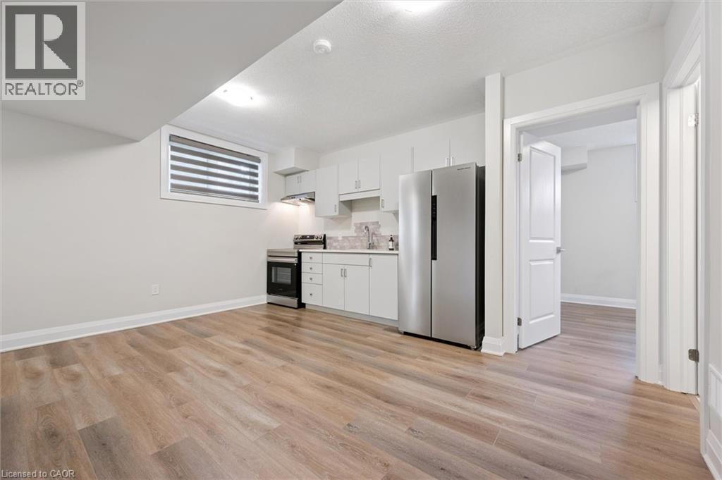 A kitchen with white cabinets and a refrigerator.