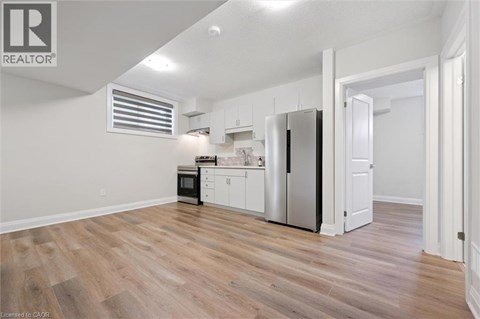 A kitchen with white cabinets and a refrigerator.