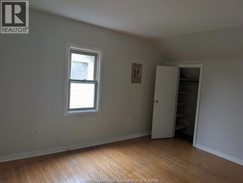 A room with a window and a closet.