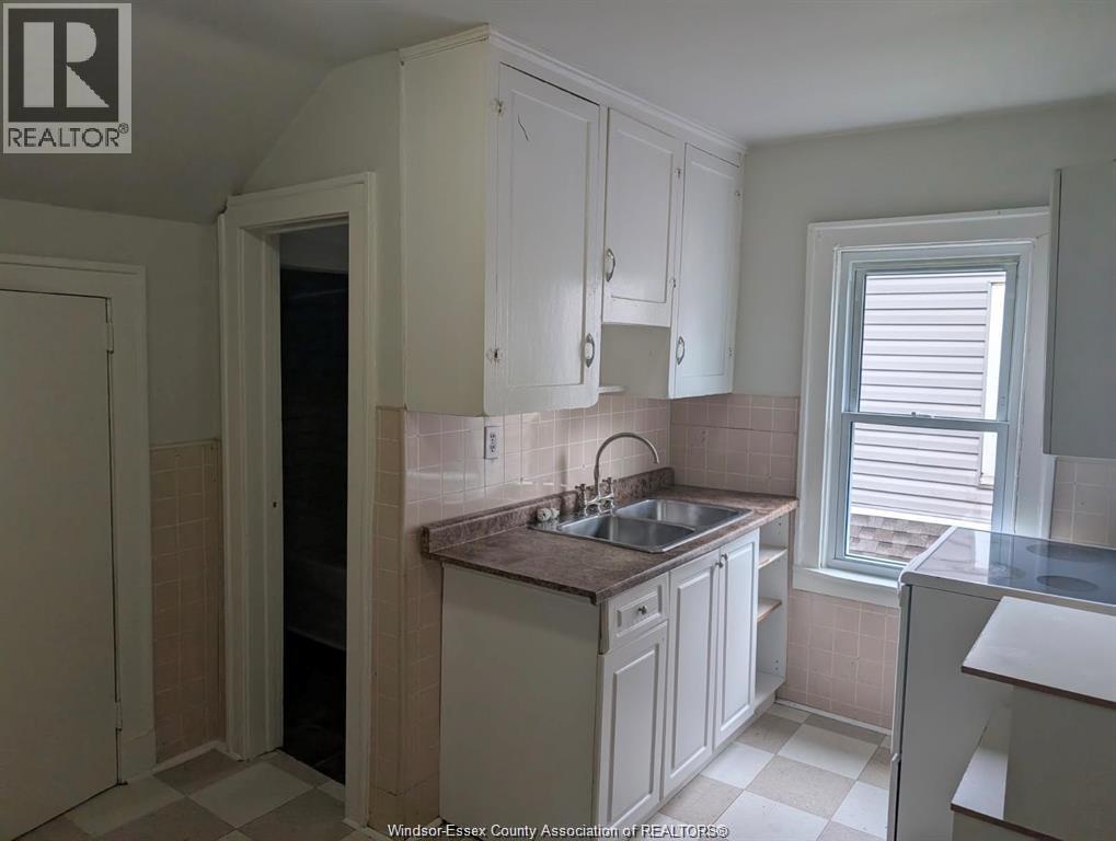 A kitchen with white cabinets and a tiled backsplash.