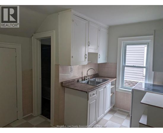 A kitchen with white cabinets and a tiled backsplash.