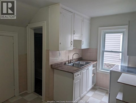 A kitchen with white cabinets and a tiled backsplash.
