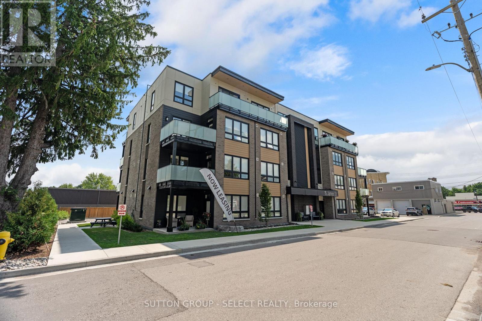 A modern multi-story building with a glass entrance and balcony.