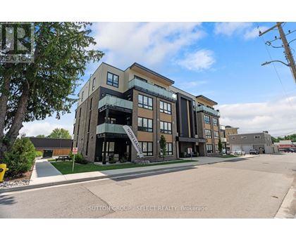 A modern multi-story building with a glass entrance and balcony.