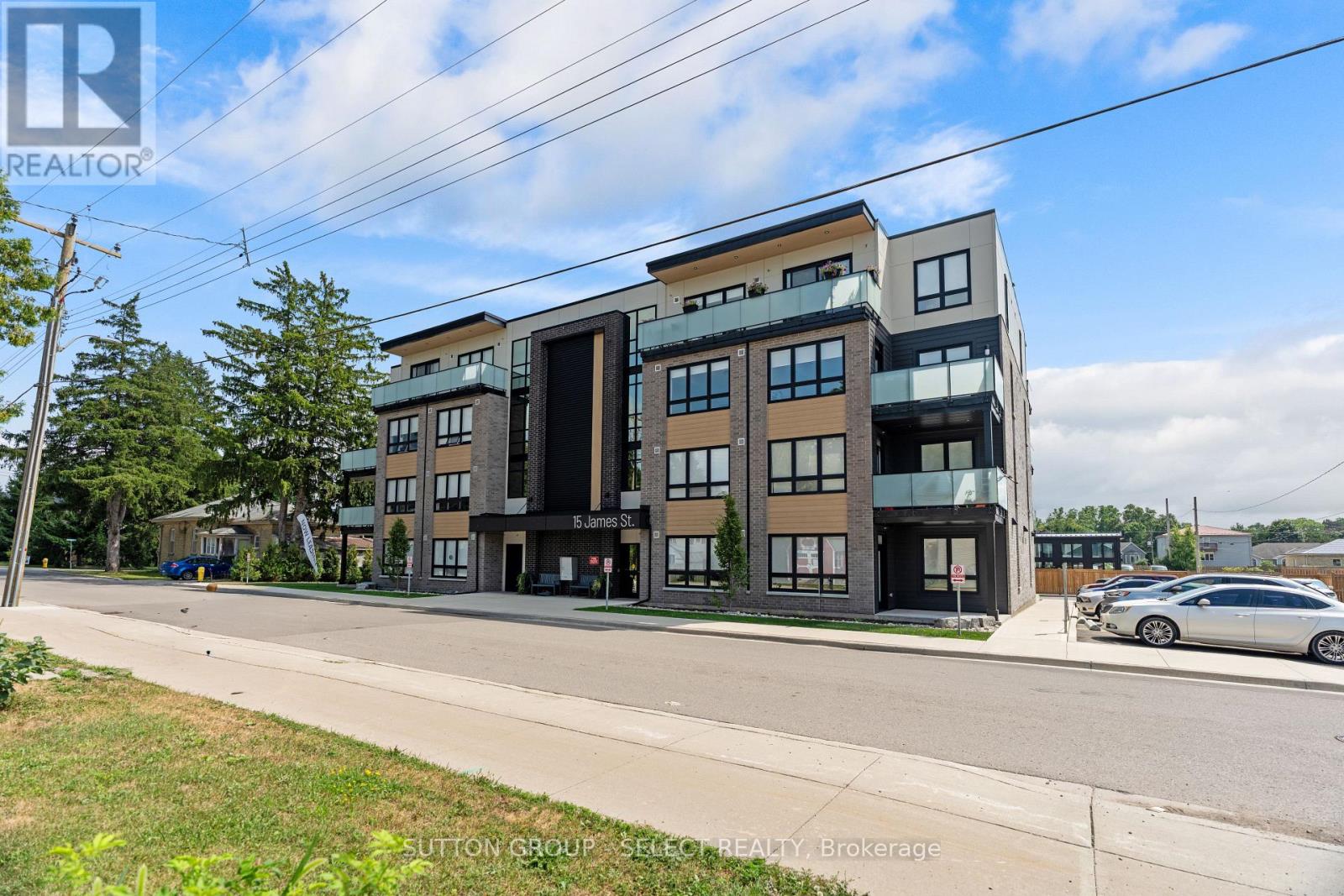 A modern multi-story apartment building with a car parked in front.