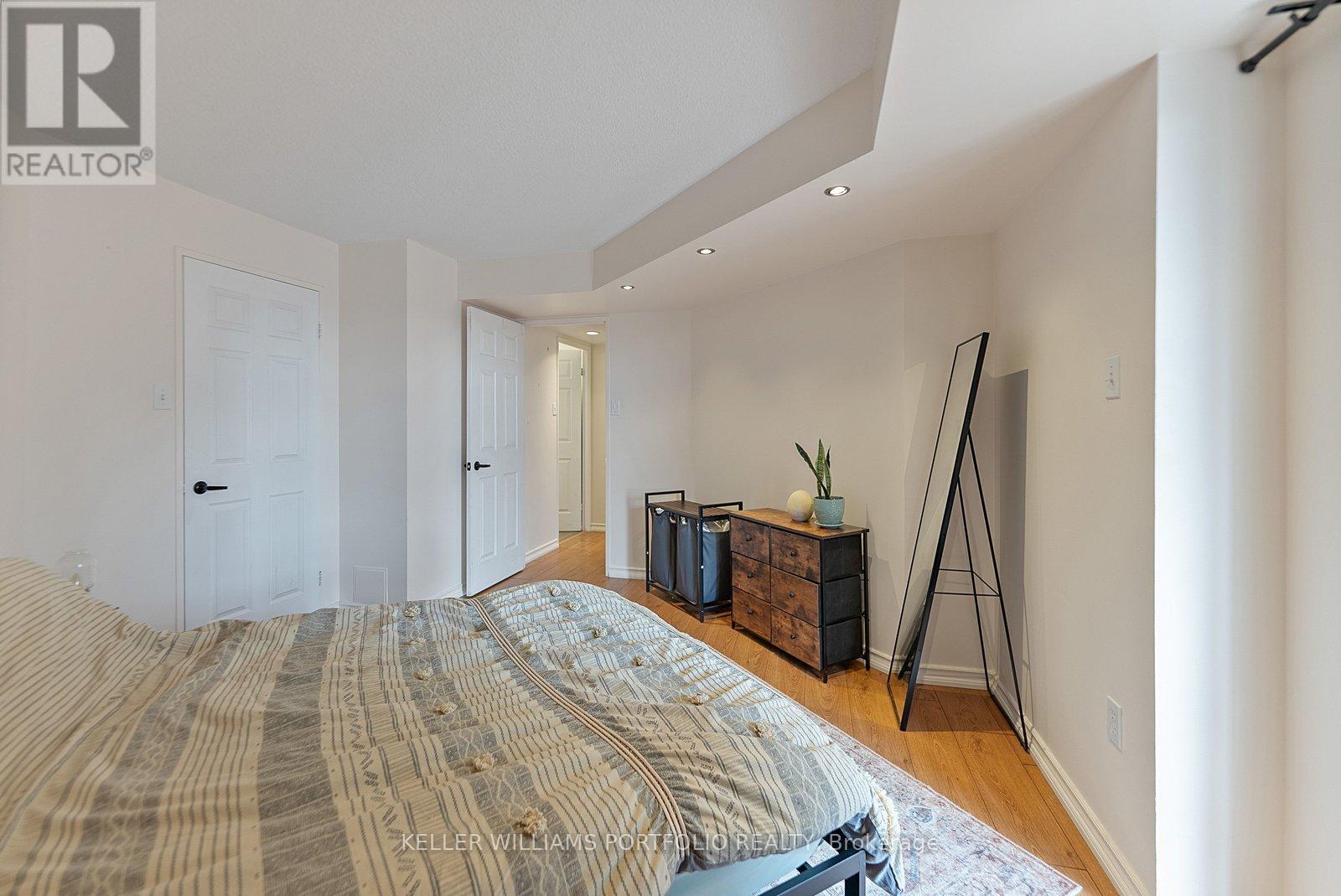 A bedroom with a large bed and a wooden cabinet.
