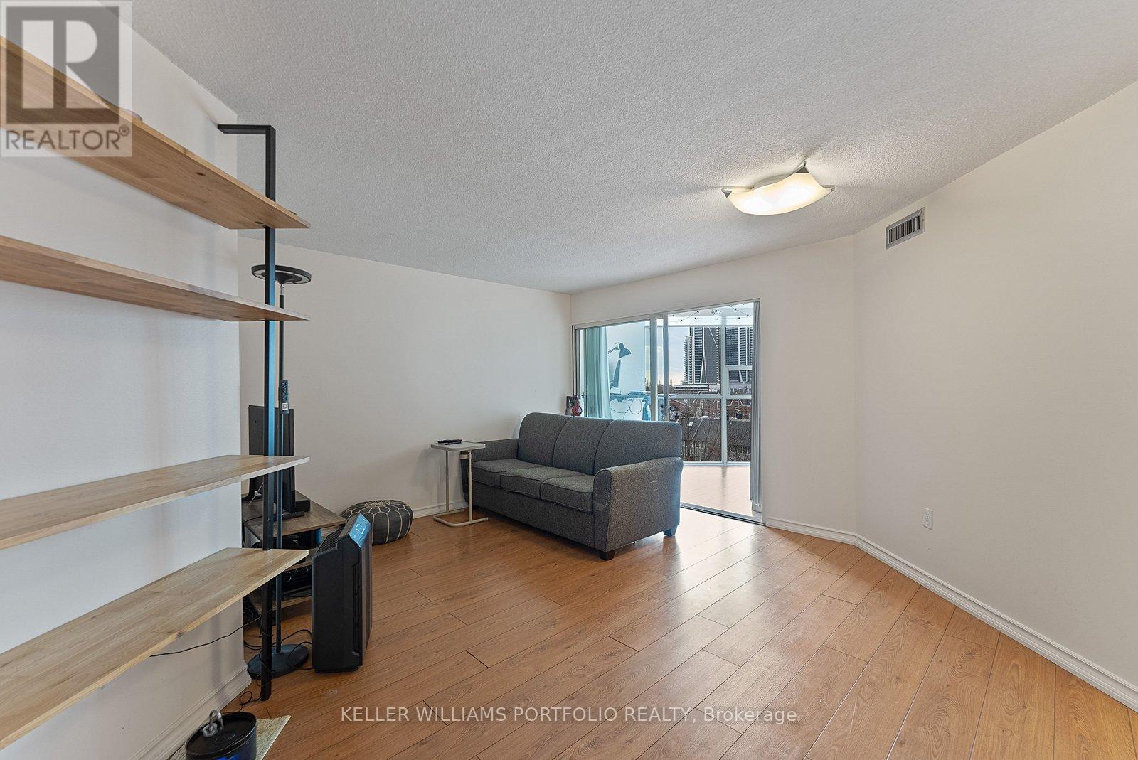 A living room with a grey couch and a wooden floor.