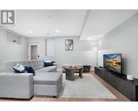 A living room with grey couches and a flat screen TV.