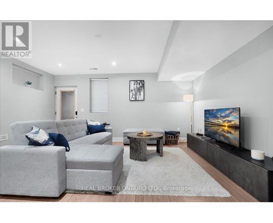 A living room with grey couches and a flat screen TV.