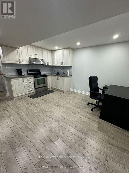 A kitchen with a black counter and a black chair.