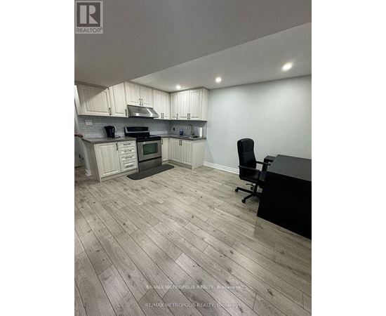 A kitchen with a black counter and a black chair.