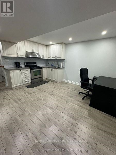 A kitchen with a black counter and a black chair.
