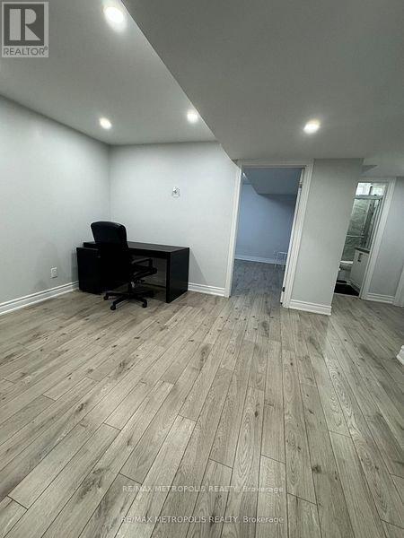 A room with a wooden floor and a black office chair.