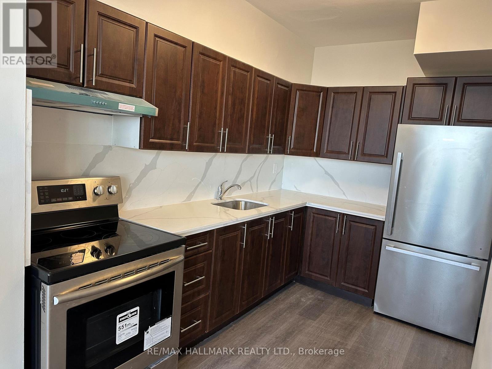 A kitchen with dark wood cabinets and stainless steel appliances.