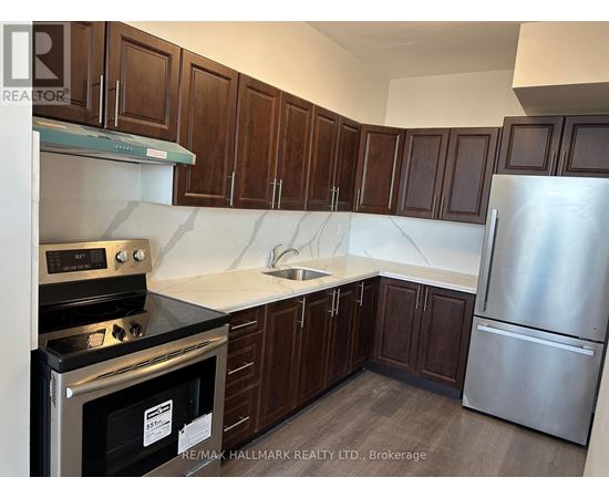 A kitchen with dark wood cabinets and stainless steel appliances.