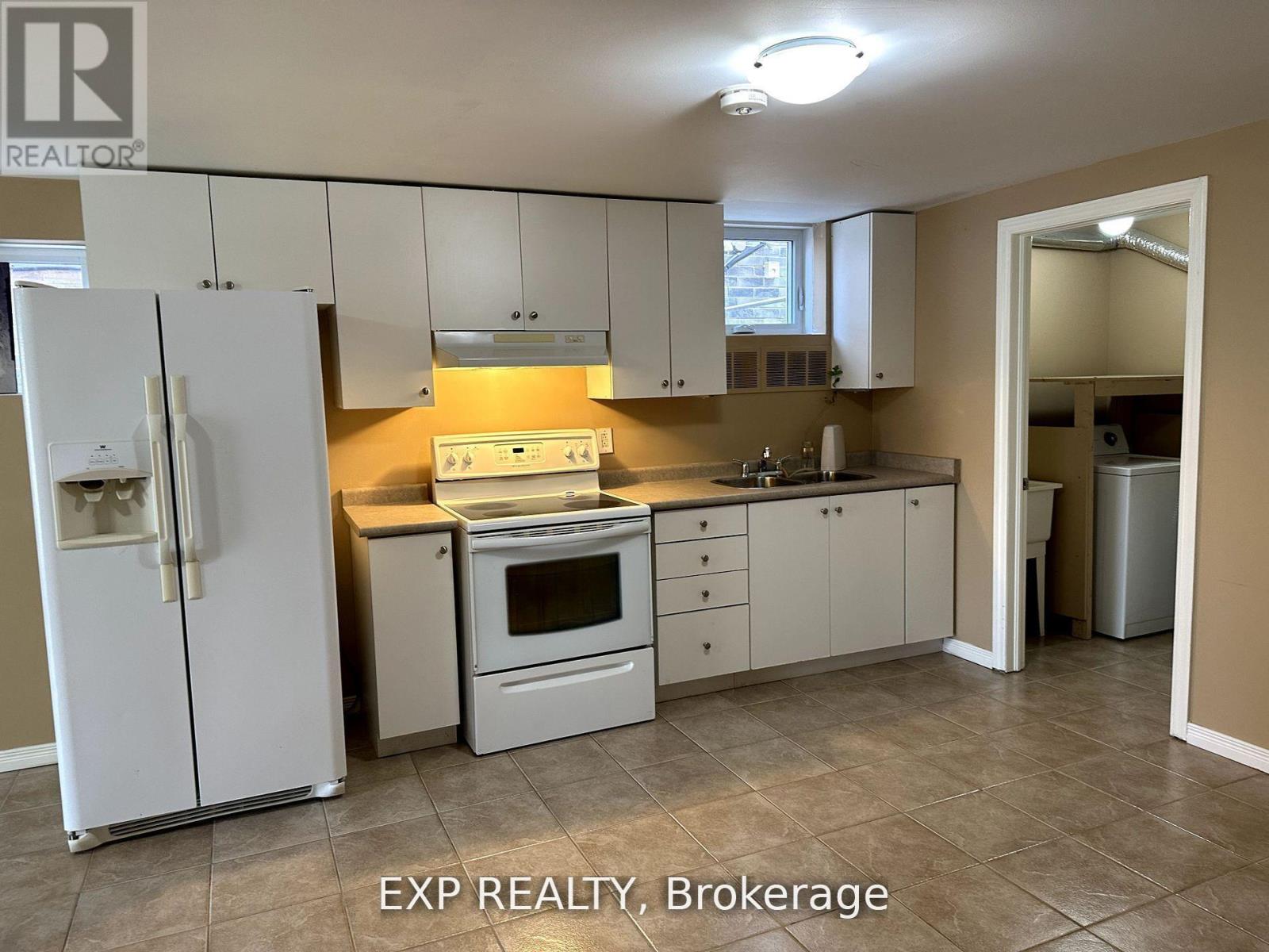 A kitchen with white appliances and cabinets.