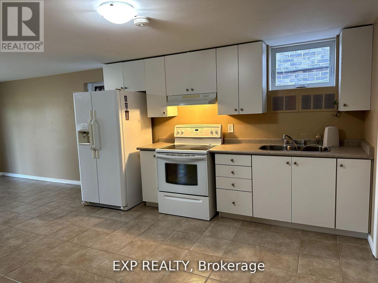A kitchen with white appliances and cabinets.