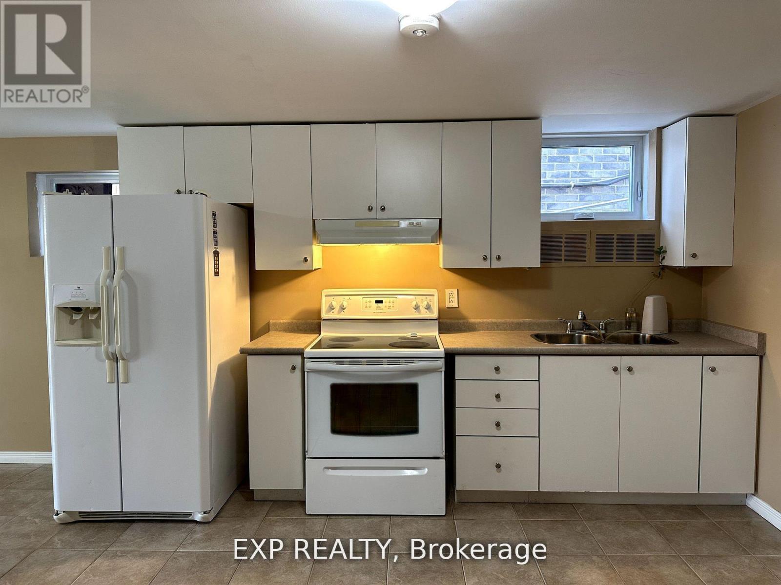 A kitchen with white cabinets and appliances is for sale.