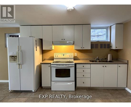 A kitchen with white cabinets and appliances is for sale.
