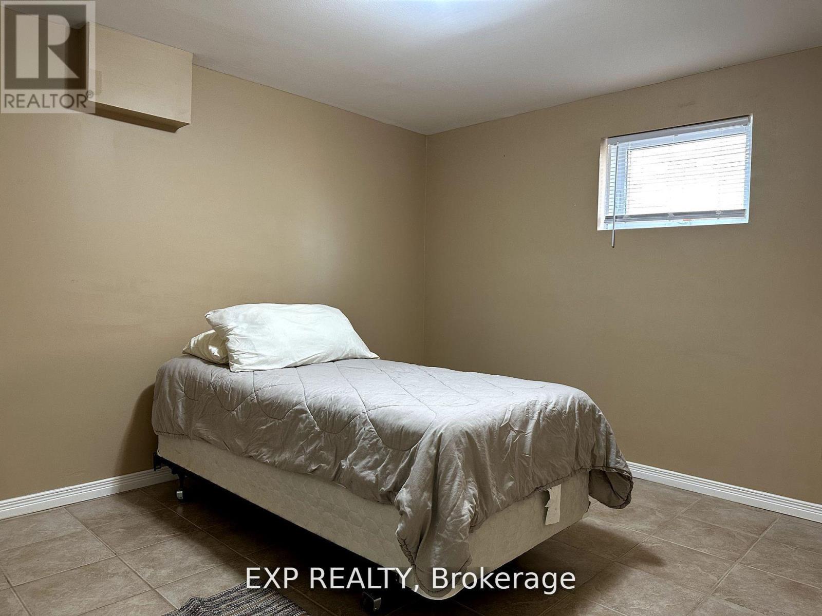A bedroom with a bed, pillow, and a window.