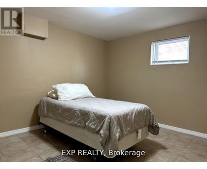 A bedroom with a bed, pillow, and a window.