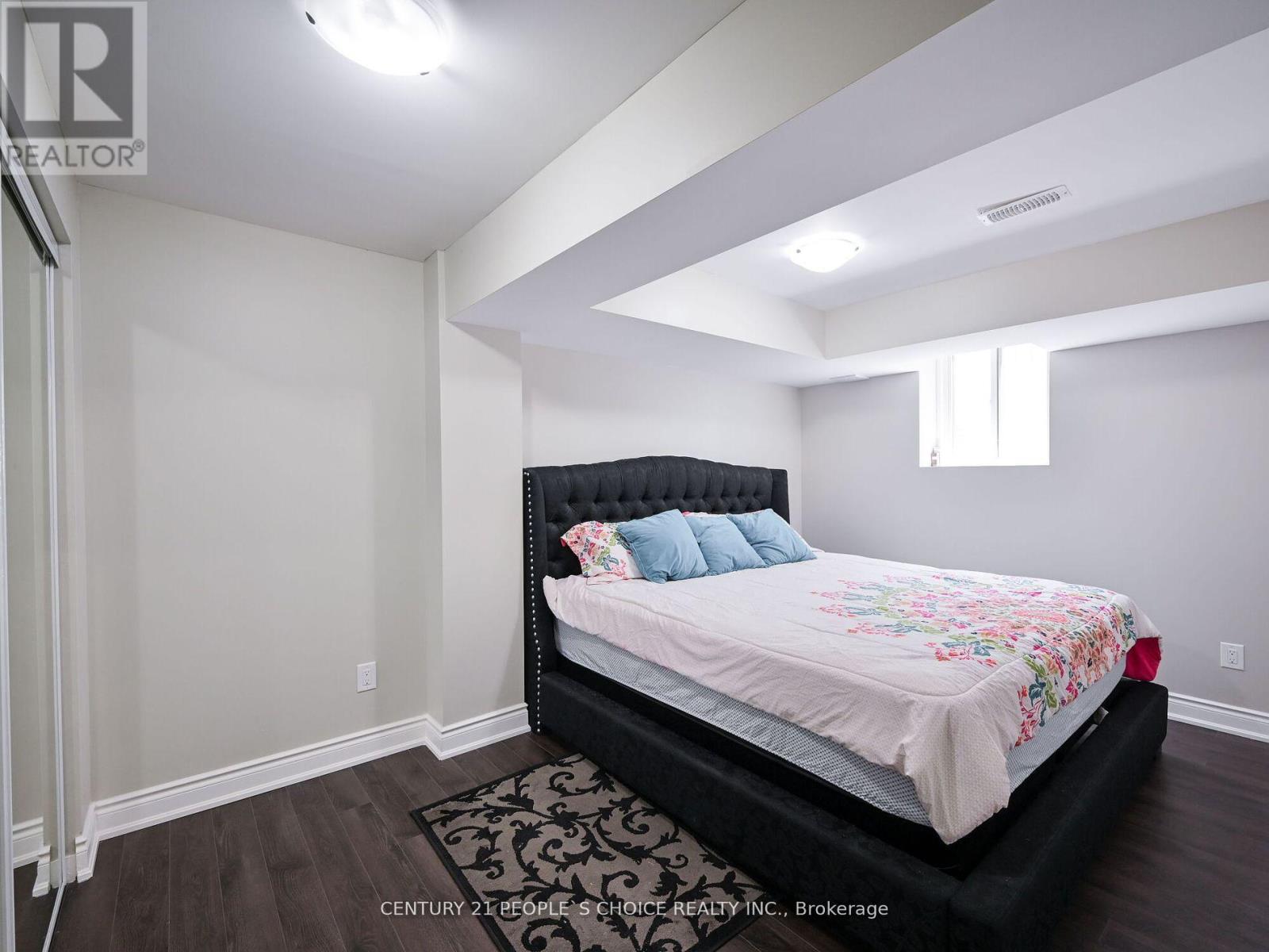 A bedroom with a black bed and a floral bedspread.
