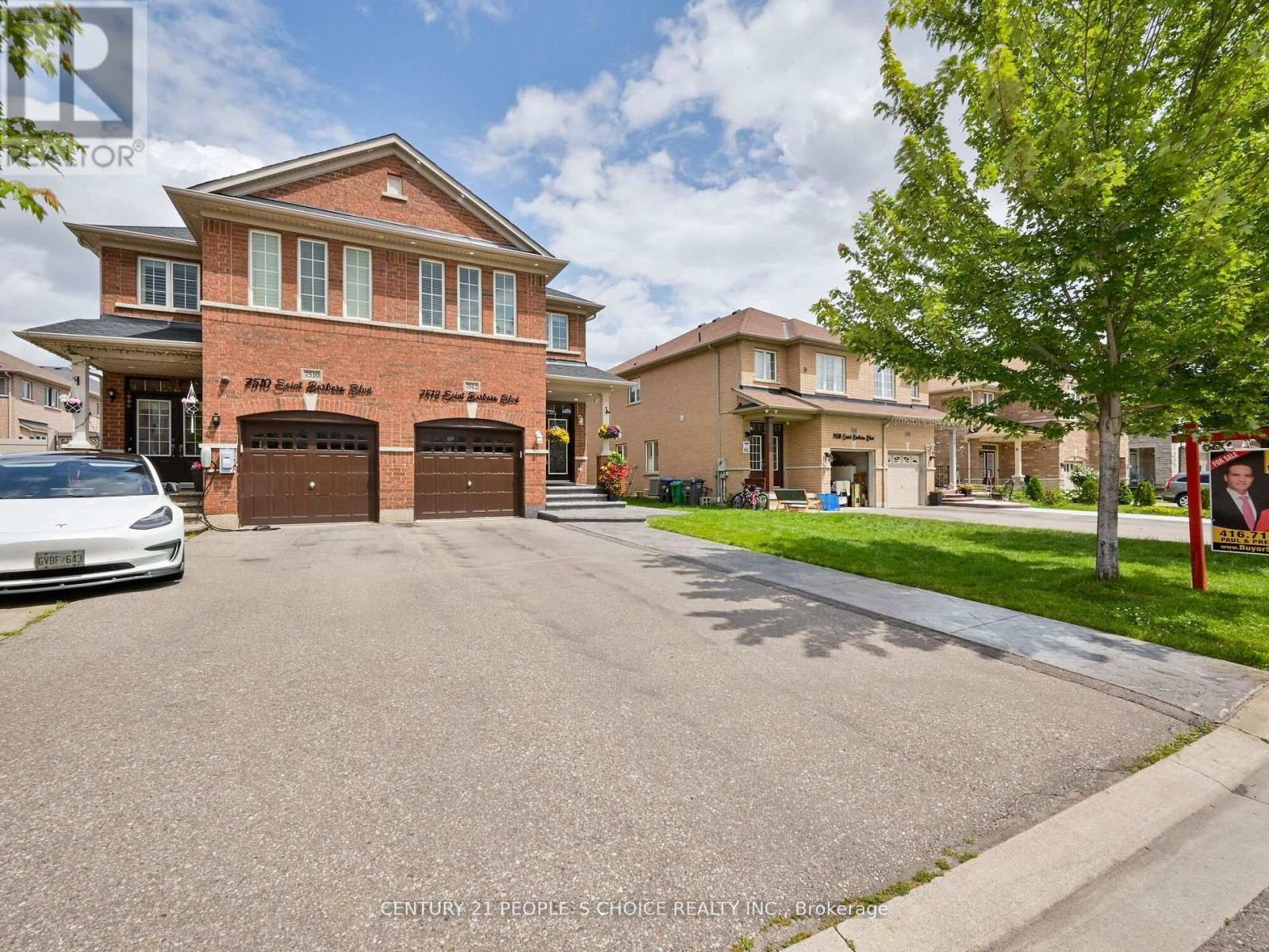A white car is parked in front of a brick house.